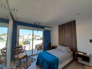 1 dormitorio con cama y vistas a un balcón en Casa Quinta FP en Rio Cuarto en Río Cuarto