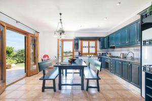 a kitchen with blue cabinets and a table and chairs at Ca'l Berros in Alcudia