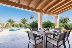a patio with a table and chairs and a pool at Ca'l Berros in Alcudia