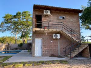 un edificio in mattoni con scala accanto a una piscina di shalom salomón- punta iglesia dúplex - cabañas a Paso de la Patria
