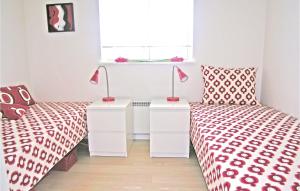 two beds with red and white sheets and lamps in a room at 3 Bedroom Beautiful Home In Nysted in Nysted