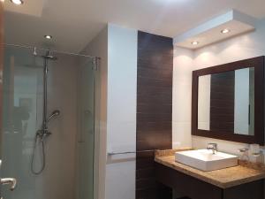 y baño con lavabo, ducha y espejo. en ELEGANTE SUITE CUMBAYA QUITO, en Quito