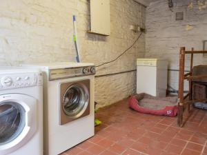 a laundry room with a washer and a washing machine at The Bothy in Walkerburn