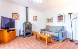 uma sala de estar com um sofá, uma televisão e um fogão a lenha em Beautiful Apartment In Alcaucn With Wifi em Alcaucín
