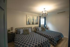 um quarto com 2 camas e um lustre em Paradise Palace Waterfront Cottage hottub 7bedroom with hottub em Bobcaygeon