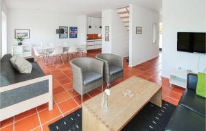 Gorgeous Apartment In Sams With Kitchen في Onsbjerg: غرفة معيشة مع أريكة وكراسي وطاولة