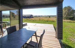 a patio with a table and chairs on a deck at Cozy Home In Samsø With Sauna in Nordby