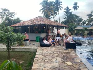 a group of people sitting in front of a pool at Handagedara Resort & Spa in Mirissa