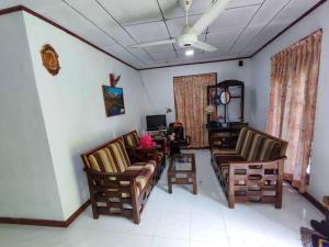 ein Wohnzimmer mit Stühlen, einem Sofa und einem Tisch in der Unterkunft Pleasant Villa in Weligama in Weligama
