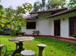 a garden with a table and chairs in front of a house at Pleasant Villa in Weligama in Weligama