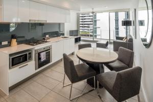 a kitchen with a table and chairs and a stove at Two bedroom apartment on Ann Street Fortitude Valley By Serain Residences in Brisbane