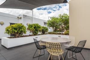 a table and chairs on a patio with plants at Two bedroom apartment on Ann Street Fortitude Valley By Serain Residences in Brisbane