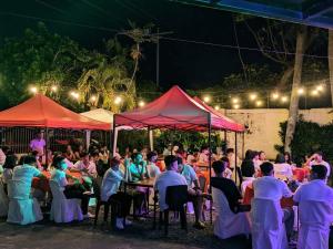 a crowd of people sitting at tables at night at Hiraya Bed and Breakfast in Roxas City