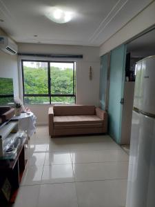 a living room with a couch and a large window at Apart-Flat Atlantic City Salvador in Salvador