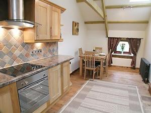 a kitchen with a table and a dining room at The Stable in North Petherwin