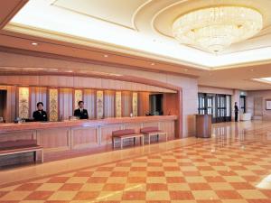 a lobby with two men standing at a bar at Hotel Okura JR Huis Ten Bosch in Sasebo