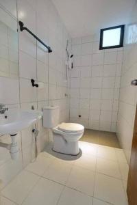 uma casa de banho branca com um WC e um lavatório em D'yana Imperio Homestay em Alor Setar