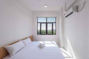 a white bedroom with a teddy bear sitting on a bed at D'yana Imperio Homestay in Alor Setar