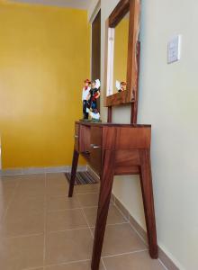 un escritorio con espejo y dos figuritas de juguete. en Xhunco House en Santa Cruz - Huatulco