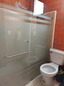 y baño con aseo y ducha acristalada. en Xhunco House en Santa Cruz - Huatulco