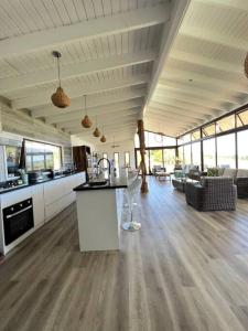 a large kitchen and living room with a woman in the background at Hare Mahatu in Hanga Roa