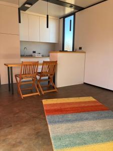 een kamer met 2 stoelen, een tafel en een keuken bij Casa Vino Andino in La Consulta