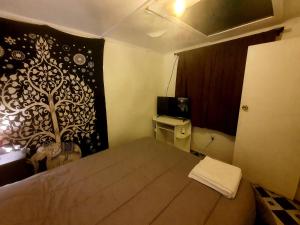 um quarto com uma cama com um mural de árvore na parede em Cabañas Holtheuer em Valdivia
