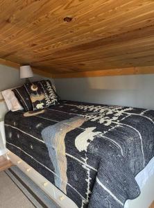 a bed in a room with a wooden ceiling at Lakehouse with Hot Tub close to Ark Encounter in Corinth