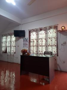 een kamer met ramen en een bureau in een kamer bij Sayura Guest House in Trincomalee