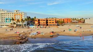 a group of people on a beach near the ocean at Playa Suites Mazatlán in Mazatlán