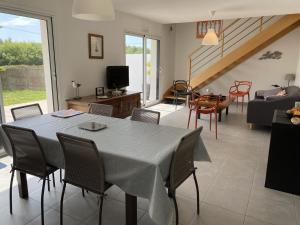 comedor y sala de estar con mesa y sillas en Maison Plouhinec, 3 pièces, 4 personnes - FR-1-397-44, en Plouhinec