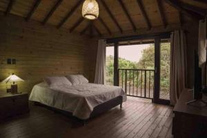 a bedroom with a bed and a large window at Mia`s cabañas in Rionegro