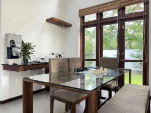 a dining room with a glass table and chairs at Villa Ema in Galle