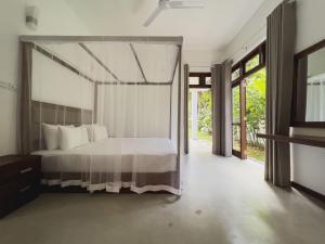 a bedroom with a bed with a canopy at Villa Ema in Galle +70 photos