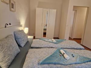 una camera con due letti e asciugamani di Bastis City Rooms a Lucerna