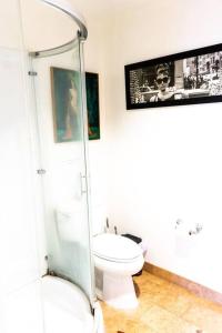 a bathroom with a toilet and a picture on the wall at Luxury Beverly Hills Apartment in Los Angeles