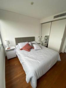 1 dormitorio con 1 cama blanca grande y 2 almohadas en Departamento en Sky Tower, en Asunción