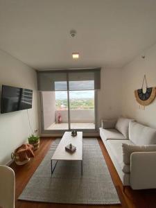 sala de estar con sofá blanco y mesa en Departamento en Sky Tower, en Asunción