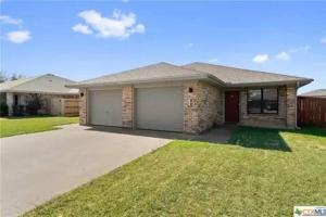 a brick house with a garage in a yard at Cozy 3bd/2bath staycation near fort hood in Killeen