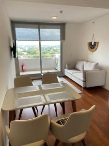 sala de estar con mesa, sillas y sofá en Departamento en Sky Tower, en Asunción