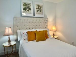 een slaapkamer met een groot wit bed met 2 lampen bij Villa Mango in Naples