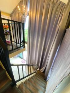 uma escada com uma janela com um lustre em บ้านสไตล์คาเฟ่วังน้ำเขียว em Ban Kom