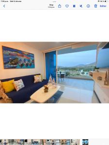 ein Wohnzimmer mit einem blauen Sofa und einem Tisch in der Unterkunft Sensacional moderno , Bello Horizonte sector Irotama , Zazue in Santa Marta