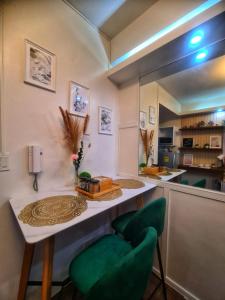 a kitchen with a table and two green chairs at Awesome Value, Great Location in Manila