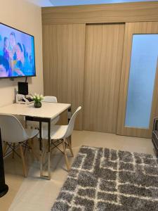Habitación con mesa, sillas y pantalla. en Katei elegantly designed 1-bedroom facing amenity en Manila