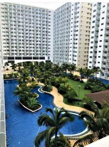 an aerial view of a resort with palm trees and water at Katei elegantly designed 1-bedroom facing amenity in Manila
