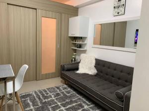 salon z czarną kanapą i stołem w obiekcie Katei elegantly designed 1-bedroom facing amenity w mieście Manila