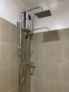 una ducha con cabezal de ducha en un baño en Katei elegantly designed 1-bedroom facing amenity, en Manila