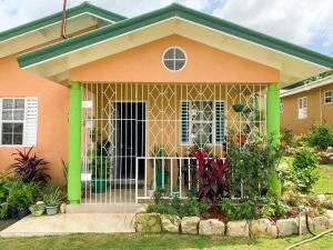 a house with a gate in front of it at Drax Hall Retreat- Ocho Rios- Cozy Villa in Mammee Bay