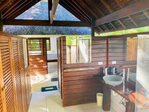 uma casa de banho com paredes de madeira e um lavatório em Freshwater Private Resort em Luganville